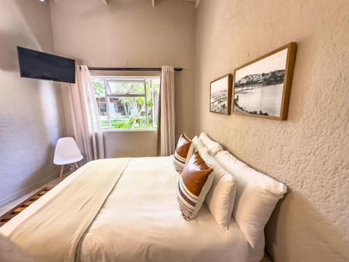 a bedroom with a bed with pillows and a window at Brinkley's River Village in Klein Brak Rivier