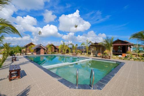 a large swimming pool in a resort with palm trees at PULANG RESORT in Setiu