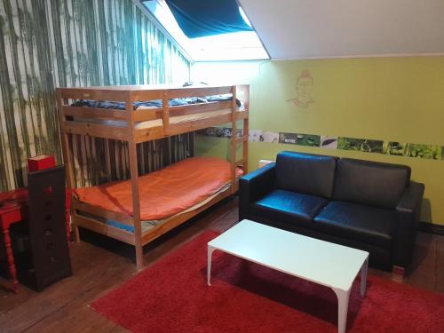 salon z łóżkiem piętrowym i kanapą w obiekcie cottage w mieście Condé-sur-Noireau