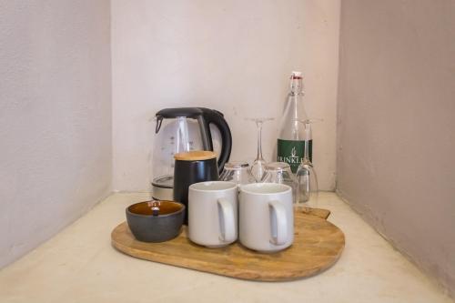 a counter with three mugs on a cutting board at Brinkley's River Village in Klein Brak Rivier