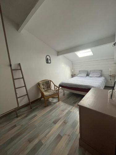 - une chambre avec un lit, une échelle et une chaise dans l'établissement Appartement Hossegor les pieds dans l'eau, à Soorts-Hossegor