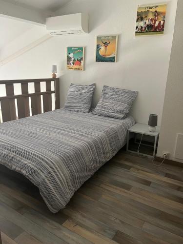 - une chambre avec un lit et une couette à rayures dans l'établissement Appartement Hossegor les pieds dans l'eau, à Soorts-Hossegor