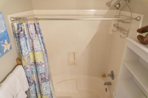 a bathroom with a tub and a shower curtain at Beach Front Destin Condo Daily Beach Service - Blue Dolphin in Fort Walton Beach