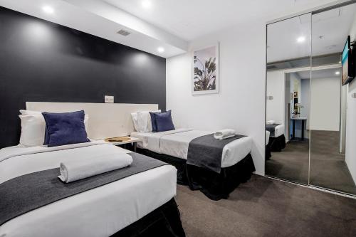 a hotel room with two beds and a shower at Circle on Cavill - Self Contained & Privately Managed - Wow Stay in Gold Coast