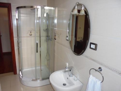 a bathroom with a shower and a sink and a mirror at Sidama Inn in Addis Ababa