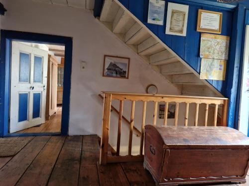 a stairway with a blue wall and a wooden stair case at Dom Przysłupowy Educare -Agroturystyka Slow Food in Świeradów-Zdrój