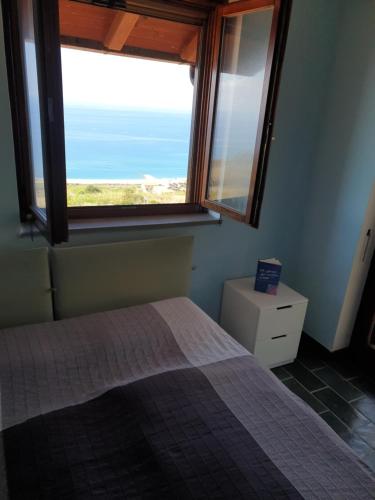 ein Schlafzimmer mit einem Bett und einem großen Fenster in der Unterkunft Casa Bonifati in Bonifati