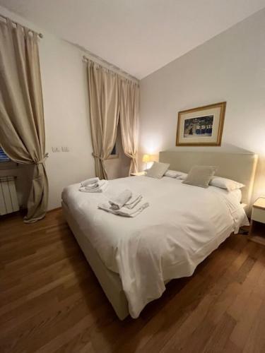 1 dormitorio con 1 cama blanca y 2 toallas en Il Borgo, en Trieste