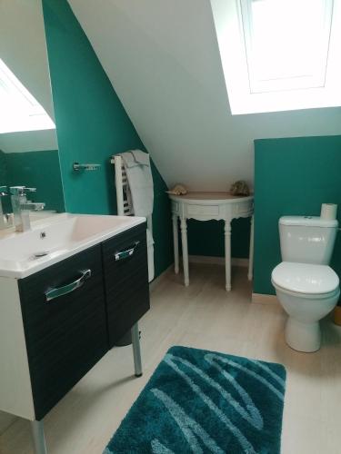 une salle de bain avec un lavabo et des toilettes et une fenêtre dans l'établissement La Planche, à Gavray