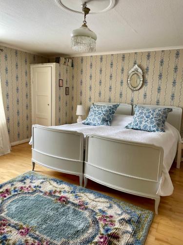 a bedroom with a large white bed and a rug at Moholms Herrgård in Moholm