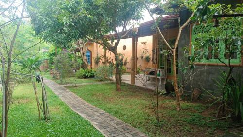 Dhee Ayurveda Villa في Malabe: منزل به ممشى بجوار ساحة