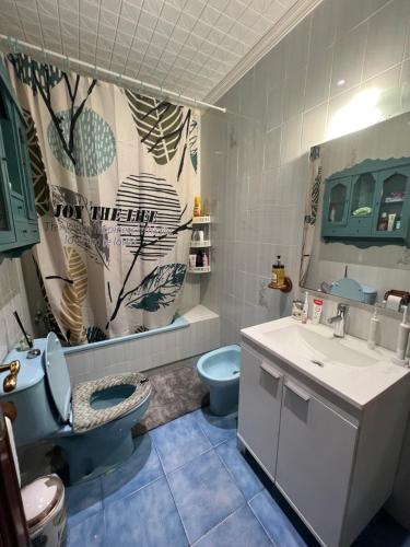 y baño con aseo azul y lavamanos. en Habitación doble junto a la playa, en Valencia