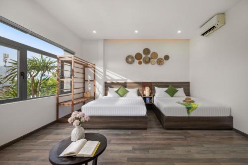 a bedroom with two beds and a table with books at Chill Home Beach Da Nang in Da Nang