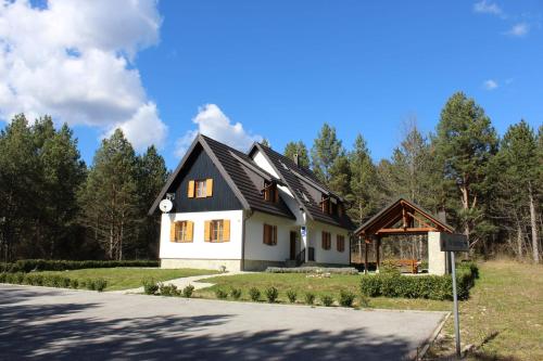 a white house with a black roof at The Starlings Apartments Plitvice Lakes in Plitvička Jezera