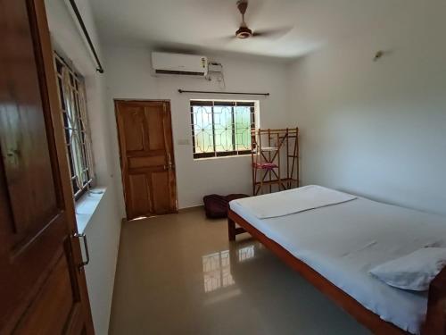 a small bedroom with a bed and a window at THE OCEAN WAVE MORJIM in Morjim