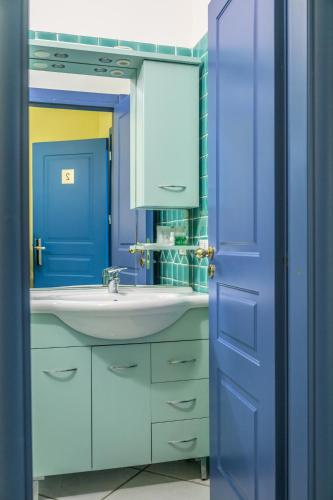 a bathroom with a sink and a blue door at Hotel Centro Congressi Polo Nautico in Salerno