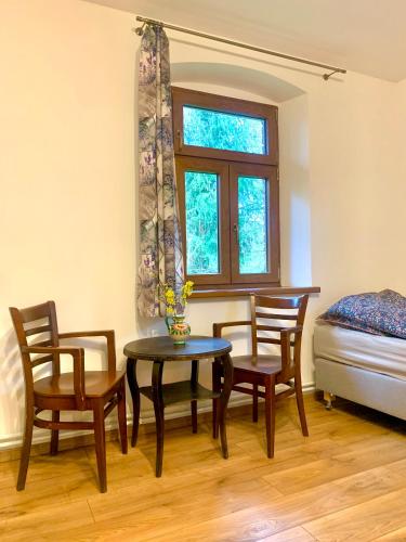 a dining room with a table and chairs and a bed at Folwark Sudecki in Marciszów