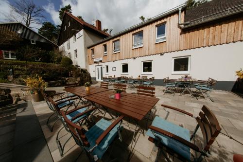 a wooden table and chairs in front of a building at Bergpension Laasen Perle Rathen in Kurort Rathen