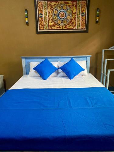 a blue and white bed with blue pillows on it at Dhee Ayurved Resort Hospital in Malabe