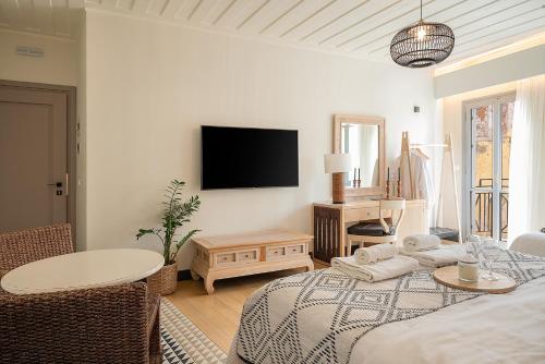 a living room with a bed and a tv on the wall at Vranas Ambiance Hotel in Chania Town