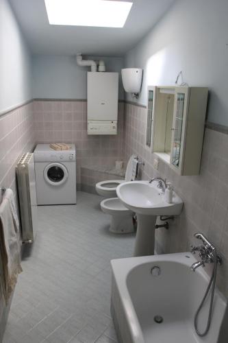 a bathroom with two toilets and a sink and a washing machine at La Fontana in Spoleto