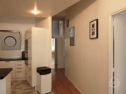 une cuisine avec des armoires blanches et un comptoir dans l'établissement Loft très calme centre de Paris, à Paris