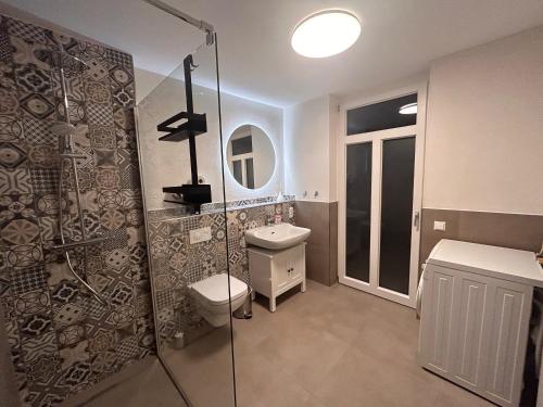 a bathroom with a shower and a toilet and a sink at Ferienwohnung Kuckucksnest in Bad Wildbad