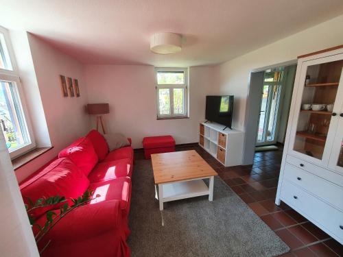 a living room with a red couch and a table at Ferienwohnung Kuckucksnest in Bad Wildbad