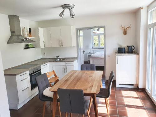 uma cozinha e sala de jantar com uma mesa de madeira e cadeiras em Ferienwohnung Kuckucksnest em Bad Wildbad