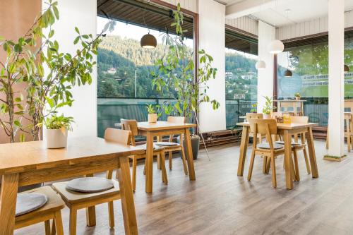 a restaurant with wooden tables and chairs and plants at Ferienwohnung Kuckucksnest in Bad Wildbad