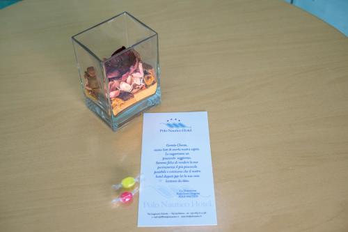 a box of candies sitting on a table with a card at Hotel Centro Congressi Polo Nautico in Salerno