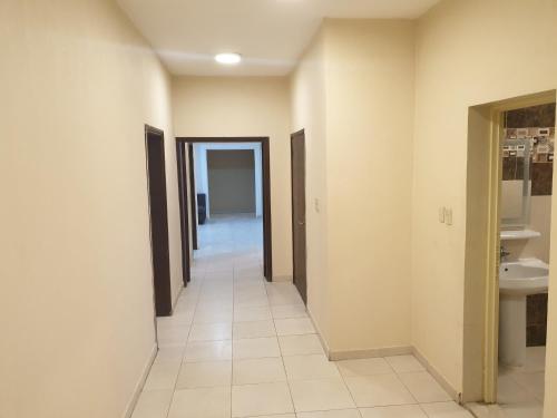 a hallway of a bathroom with two doors and a sink at Apartment for rent in Dammam