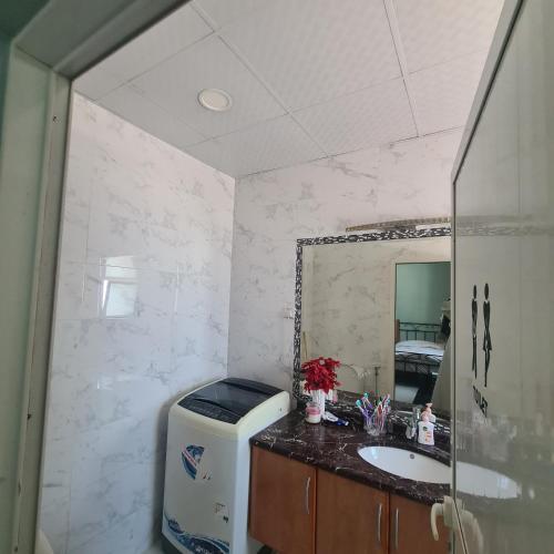 سكن مريح في دبي: حمام مع حوض ومرآة