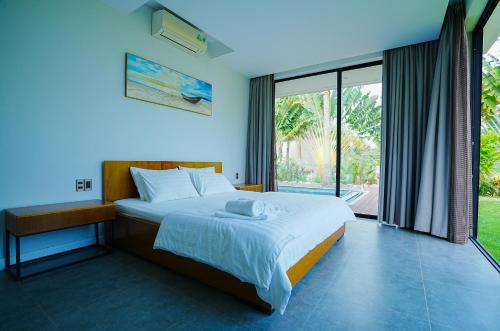 富國的住宿－Kiwuki Beachfront Villa，一间卧室设有一张床和一个大窗户