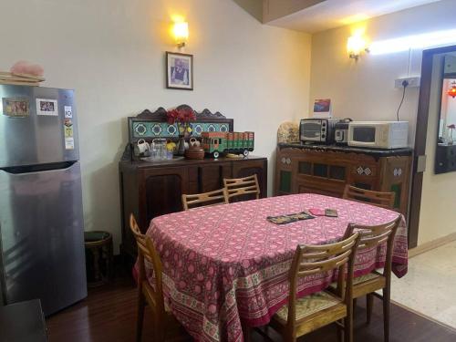 a kitchen with a table and a kitchen with a refrigerator at cozy 1 bedroom suite in Egmore, Chennai in Chennai