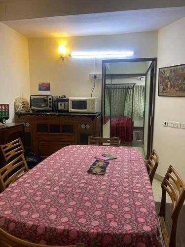 a room with a table with a pink table cloth at cozy 1 bedroom suite in Egmore, Chennai in Chennai