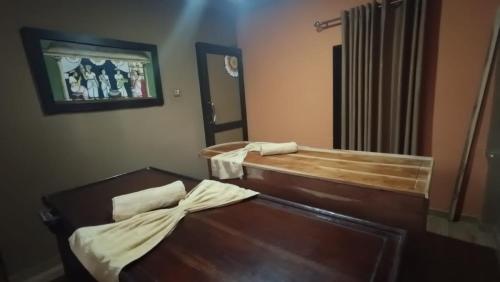 a room with a wooden bed and a mirror at Dhee Ayurved Resort Hospital in Malabe