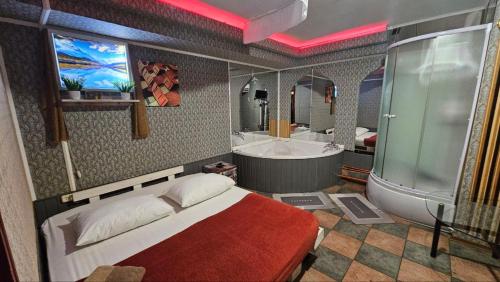 ドニプロにあるMamba Hotelのベッドルーム(ベッド1台、バスタブ、テレビ付)