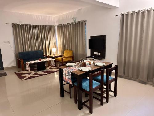 sala de estar con mesa de comedor con sillas en SKY VIEW RESORTS en Munnar