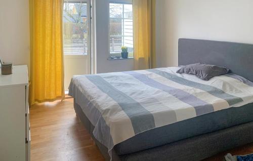 ein Bett mit einer blauen und weißen Bettdecke in einem Schlafzimmer in der Unterkunft 2 Bedroom Amazing Home In Mrbylnga in Mörbylånga