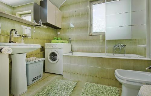 a bathroom with a sink and a washing machine at Amazing Home In Seketin With 2 Bedrooms, Wifi And Outdoor Swimming Pool in Seketin