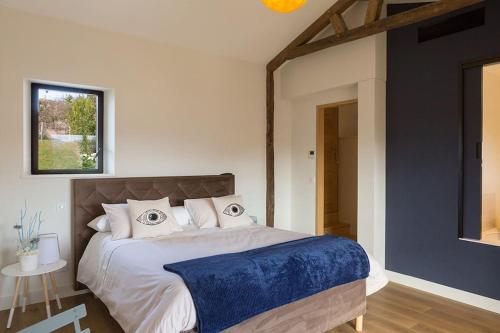 une chambre avec un grand lit avec une couverture bleue dans l'établissement Studio Baïgura - Déconnexion au Pays basque, à Hasparren