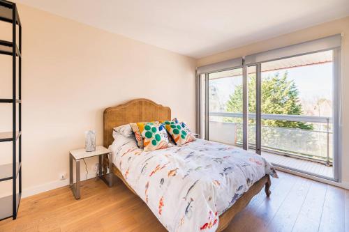 une chambre avec un lit et une grande fenêtre dans l'établissement Les Serres, bel appartement avec vue sur le phare, à Le Touquet-Paris-Plage