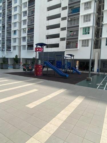 een speeltuin voor een hoog gebouw bij The Comfy Stay in Kuala Lumpur
