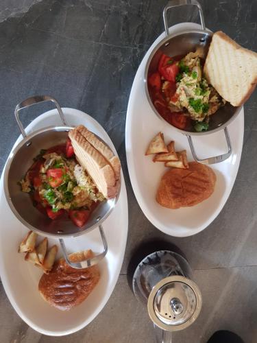 two plates of food with a pot of soup and bread at Villas Rocher - Standard Suite 3A in Grand Baie