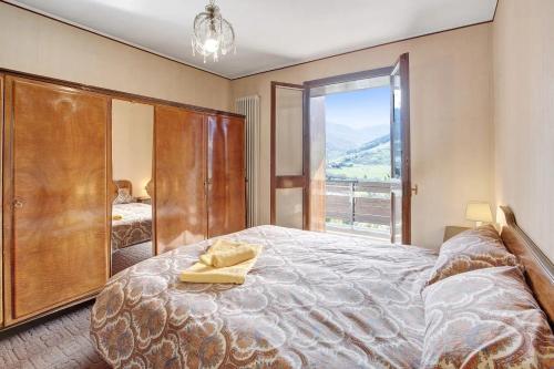 Santa Lucia的住宿－Bormio 1，一间卧室设有一张大床和一个大窗户
