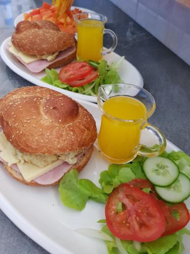 two plates of food with sandwiches and two glasses of juice at Villas Rocher - Standard Suite 3A in Grand Baie