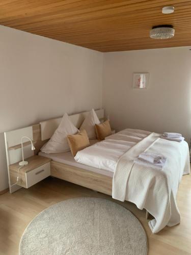 a bedroom with a large bed with a wooden ceiling at Pension zur Sonnenalb in Sonnenbühl