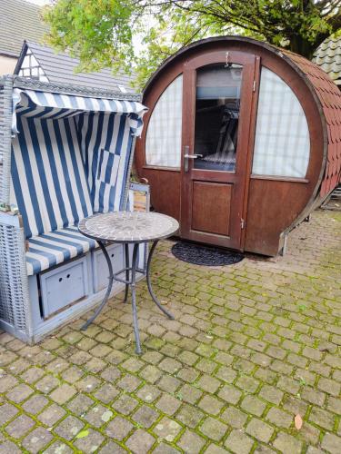 a gazebo with a table and a chair in front of a table at Für Alleinreisende-1 Person- Single Room- Rustikales freistehendes Mini Holzfass zum Schlafen, mit angrenzendem Badezimmer! in Leverkusen