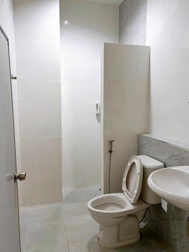 a bathroom with a toilet and a sink at Tokyo Hotel in Nakhon Ratchasima